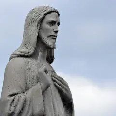 Kamienna rzeźba Jezusa z uniesionym palcem, przypominająca o nauczaniu św. Augustyna.